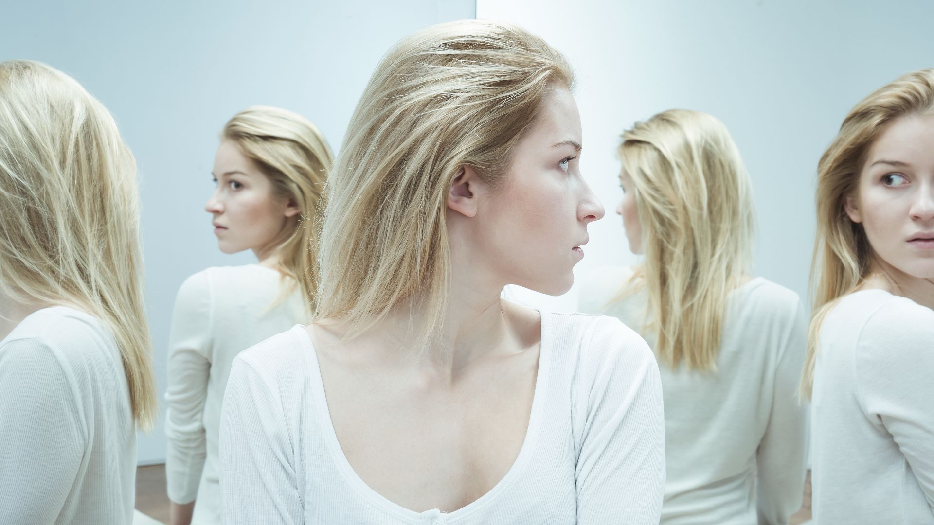A woman in a mirrored room looks over her shoulder