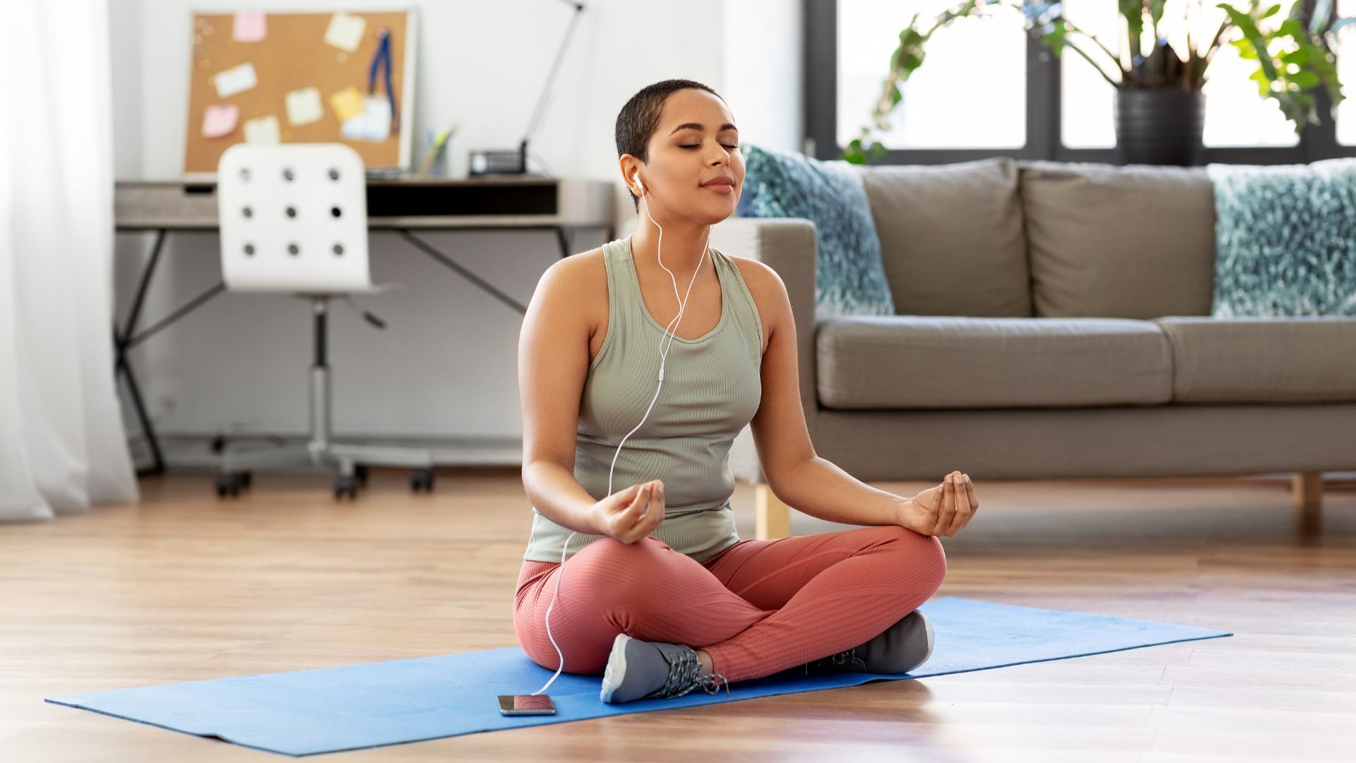 A calm woman in lotus position on a yoga mat