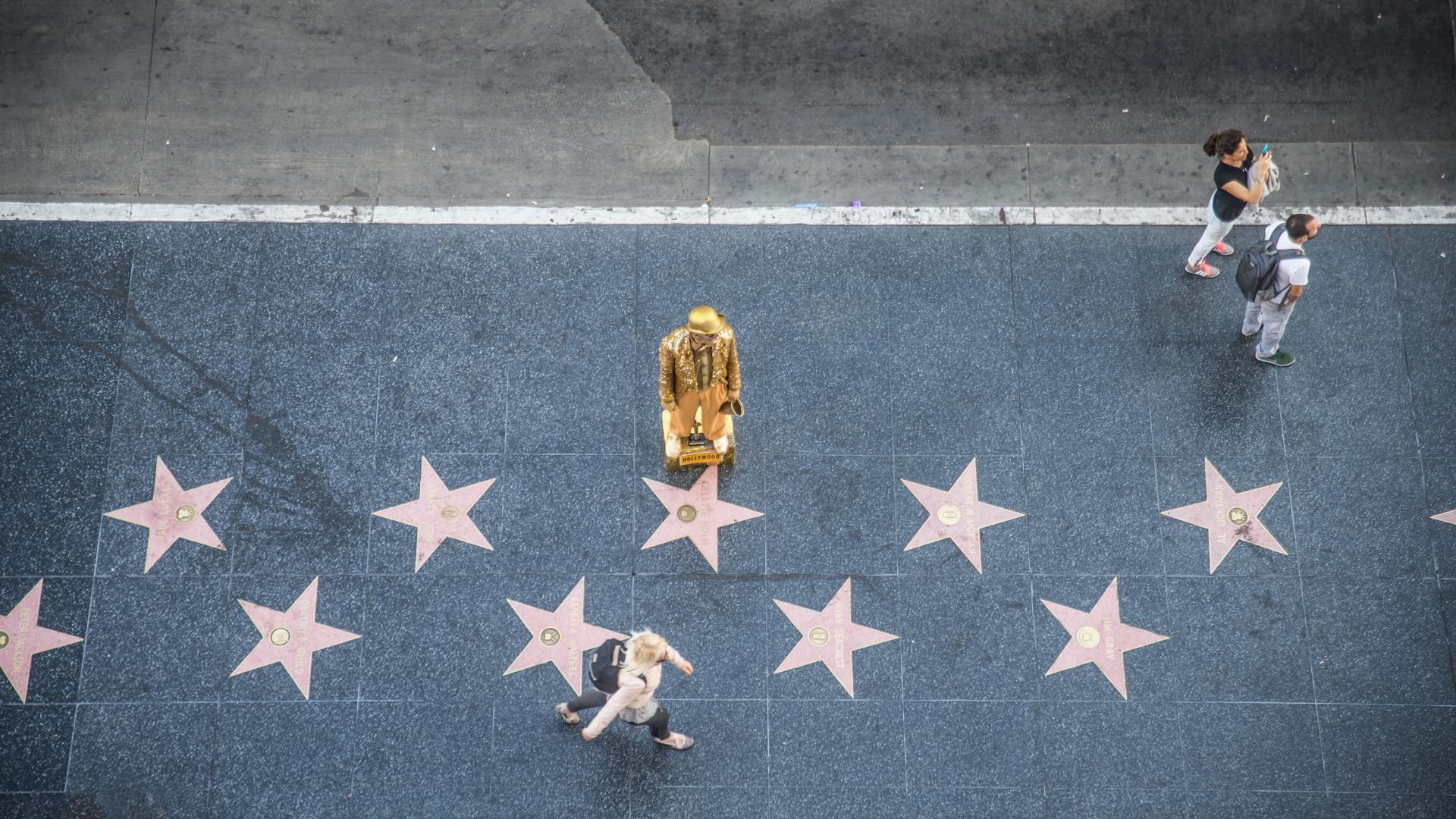 Dr Taji Huang, PhD - An Experienced Celebrity Therapist. Image: An overhead view of a man clad in gold on the Hollywood walk of stars