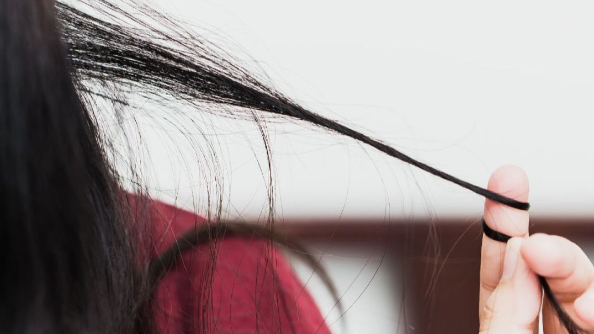 Someone tugging on their hair, with it wrapped tightly around their fingers.