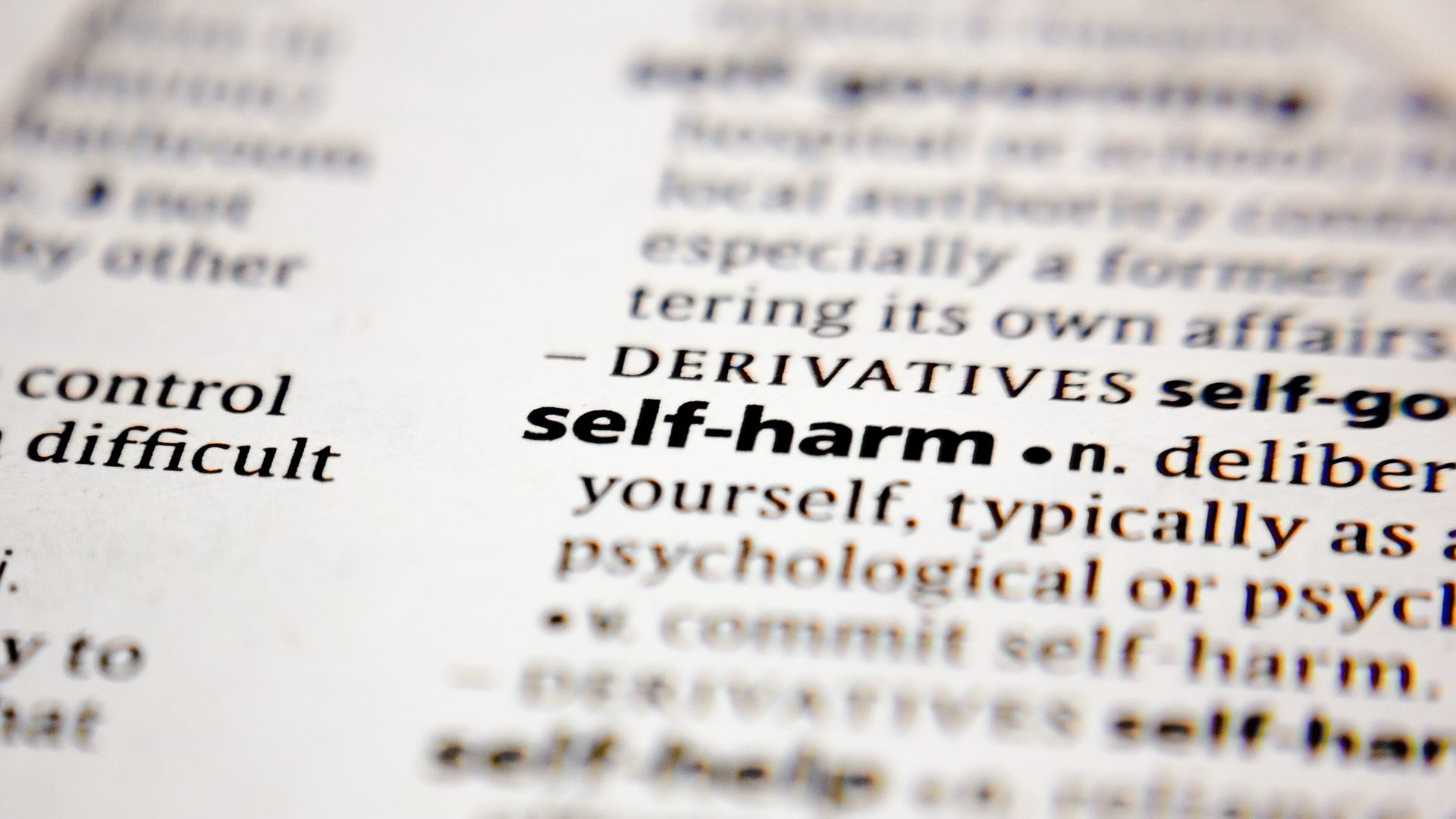 Close up image of the words "self-harm" in a book