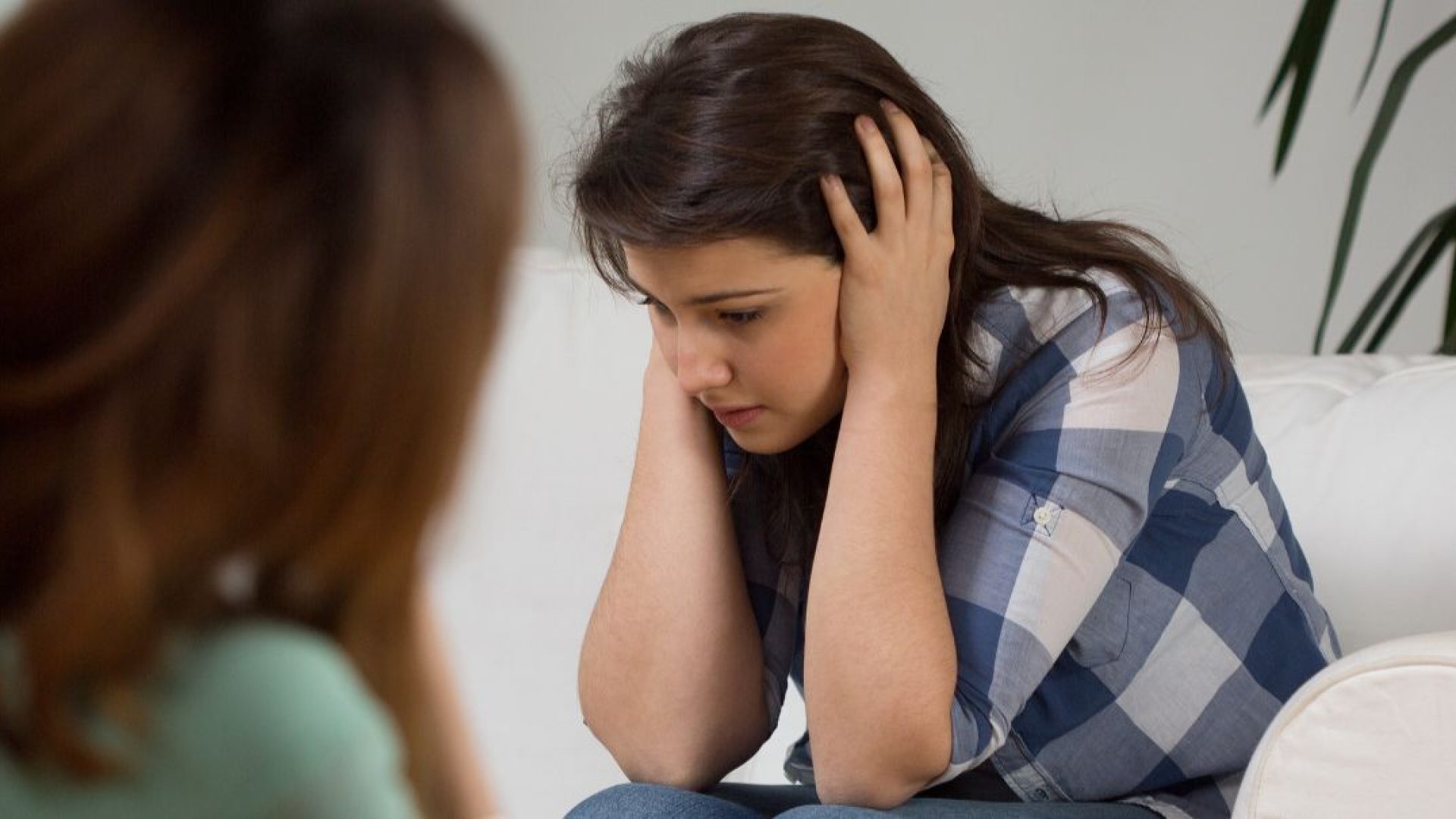 Someone who is overwhelmed and anxious on a therapist's couch.