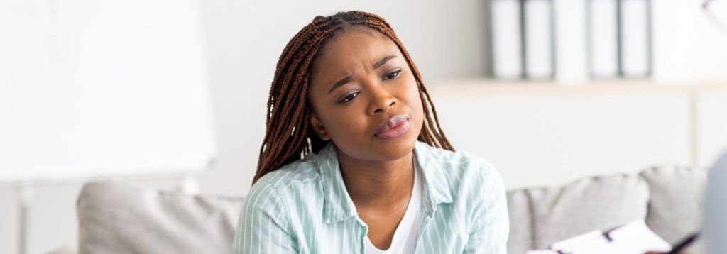 A person in therapy deep in thought and concerned.