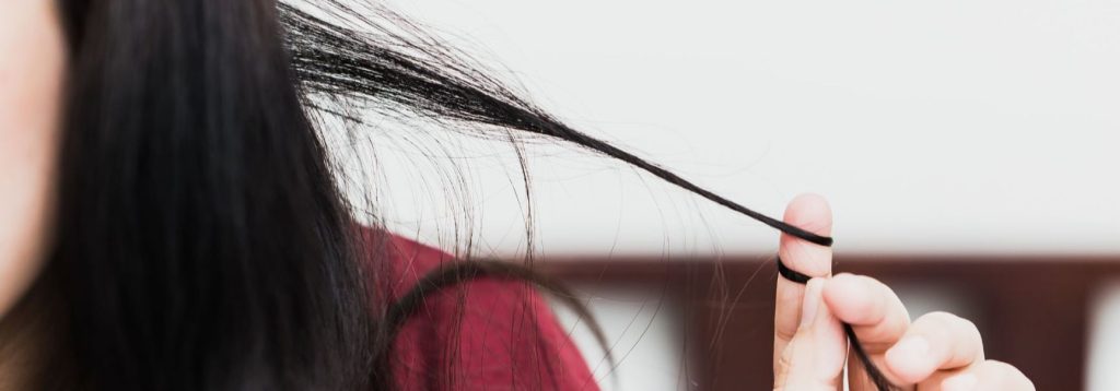 Someone tugging on their hair, with it wrapped tightly around their fingers.