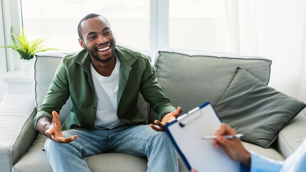 A Happy Looking Black Man Seems To Be Expressing A Breakthrough With His Therapist