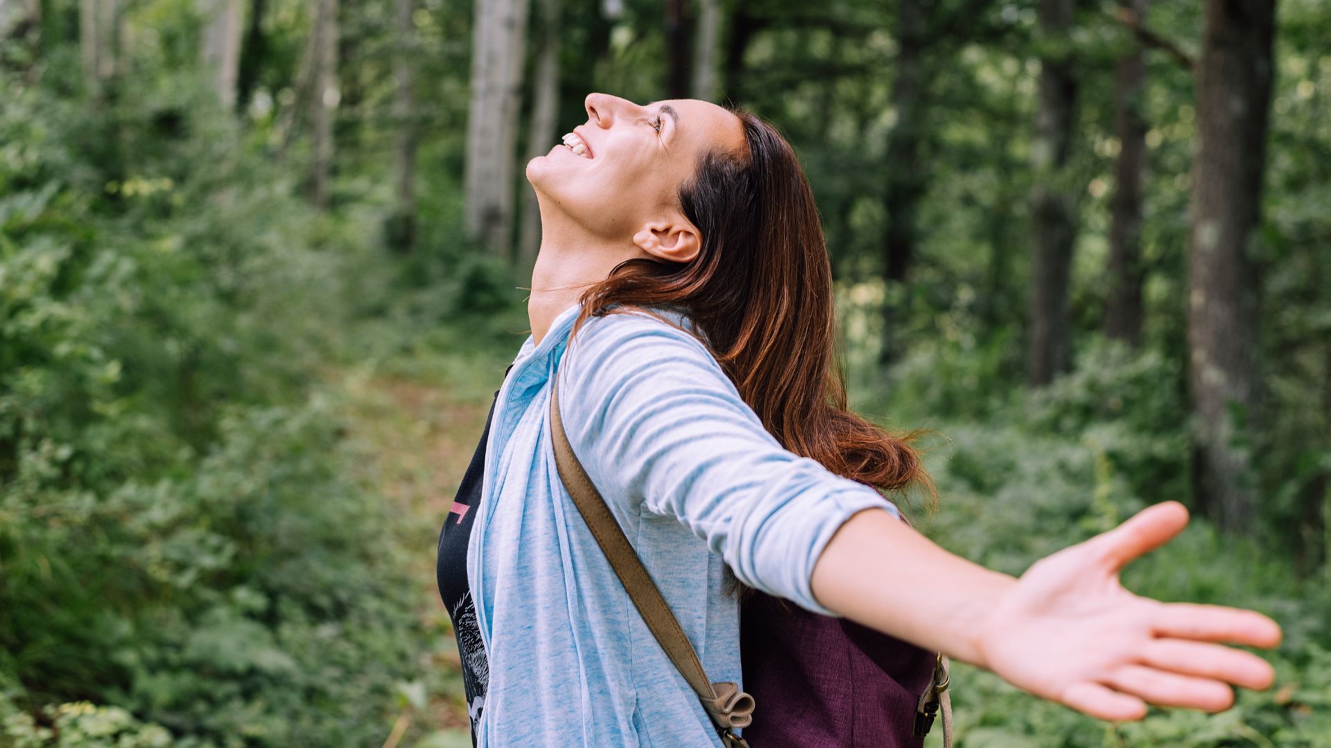 A Happy Woman With Outstretched Hands In The Forest
