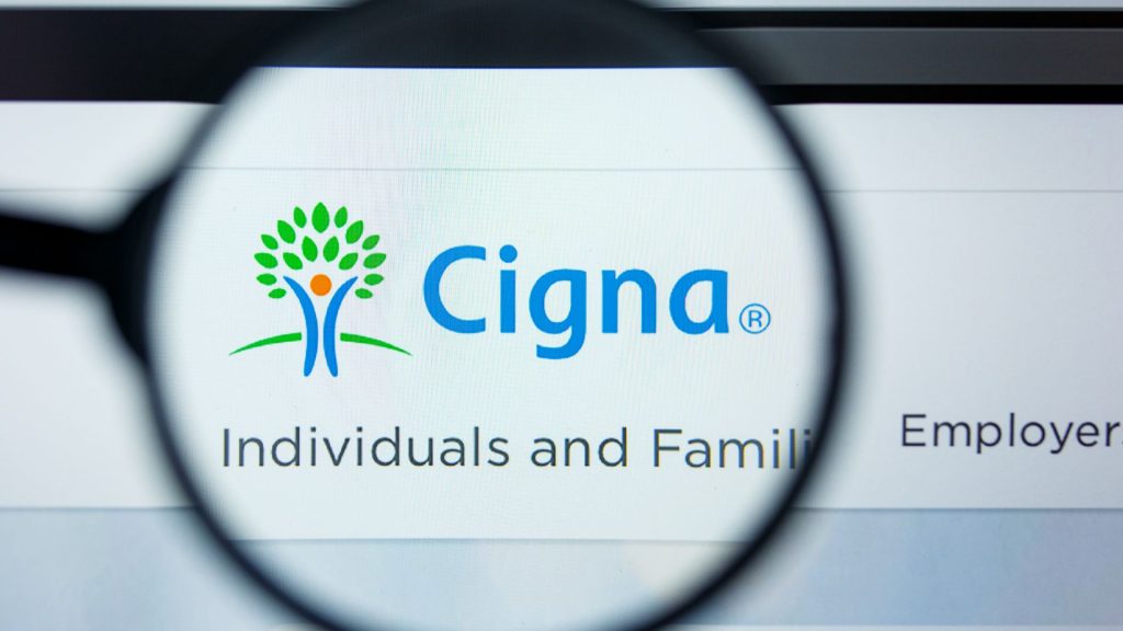 A magnifying class looking at the Cigna health insurance logo on a computer screen