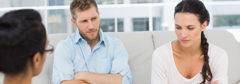 A couple talks to a therapist, both of them are unhappy and seem to be blaming each other.