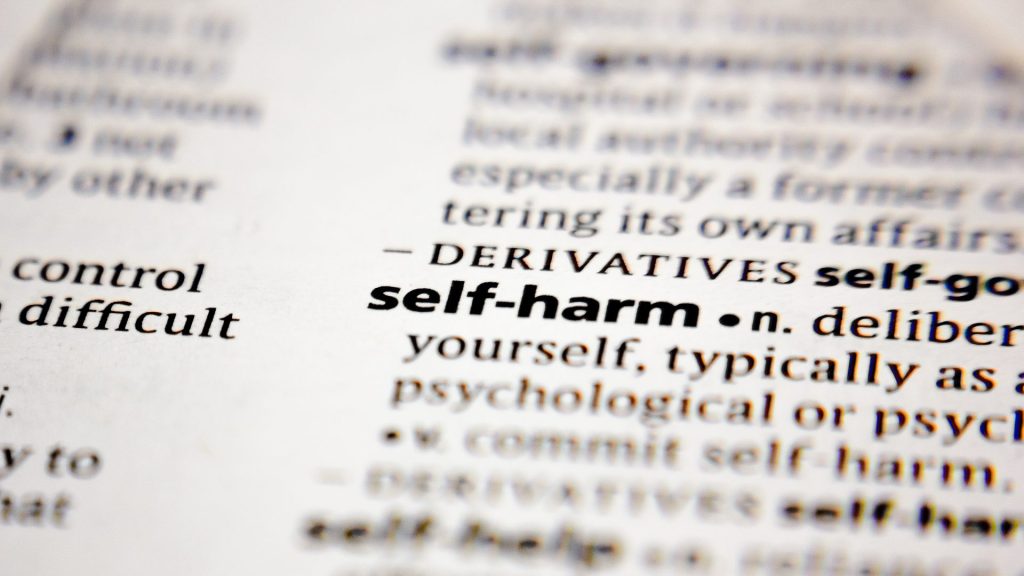 Close up image of the words "self-harm" in a book