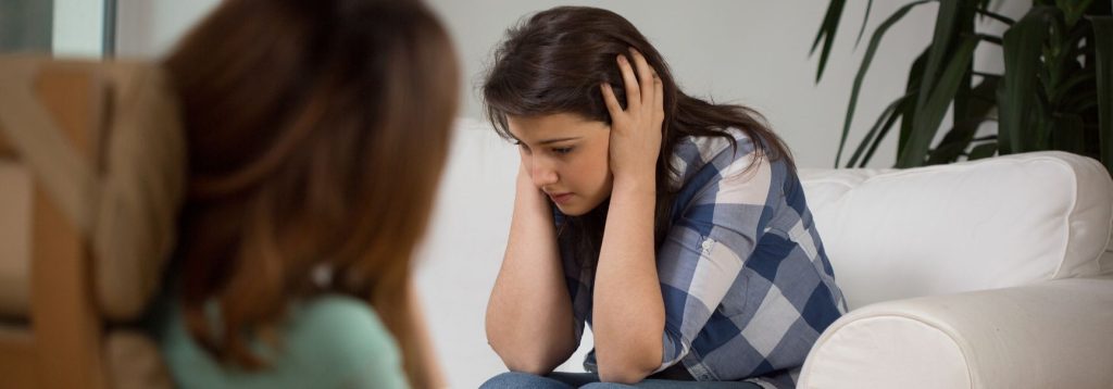 Someone who is overwhelmed and anxious on a therapist's couch.